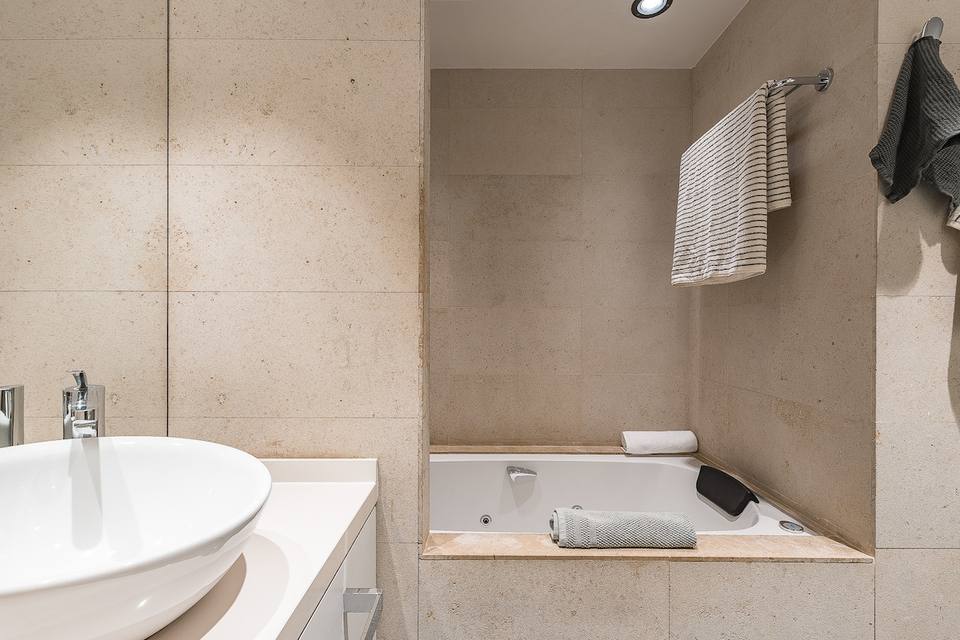 Full bathroom with stone finishes