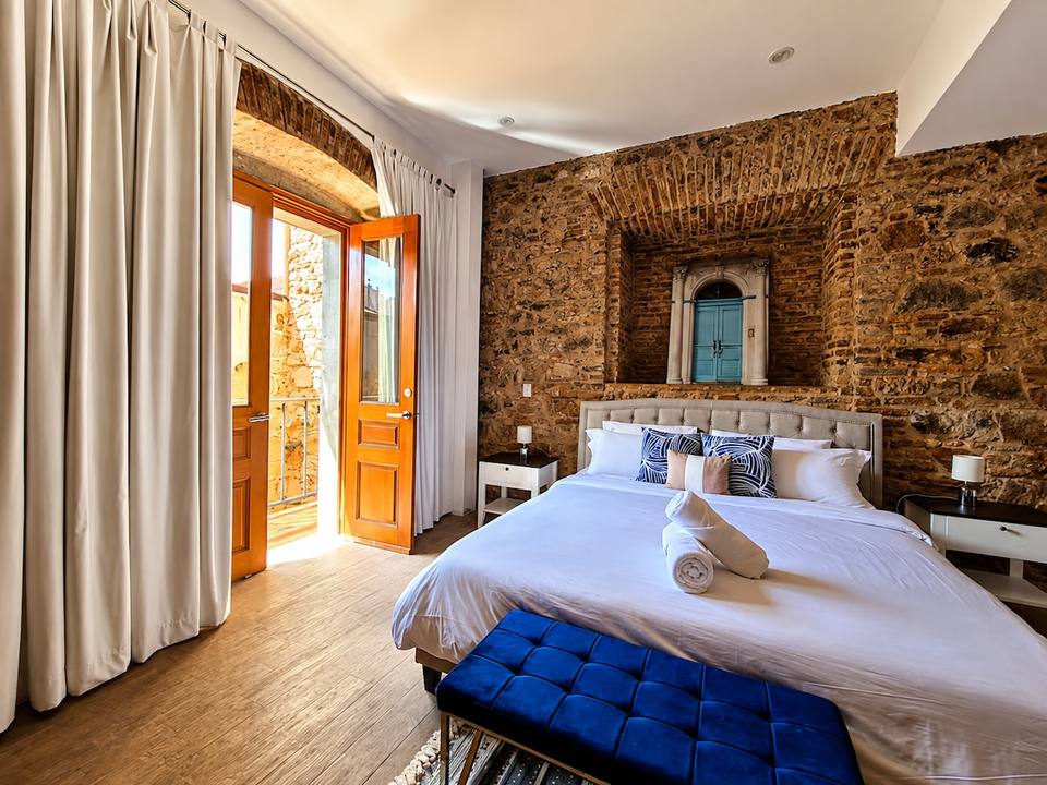 Dormitorio principal con paredes de piedra original