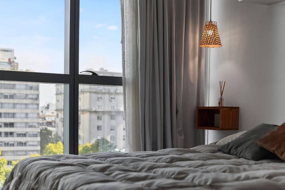 Bedside with pendant lamp and urban view