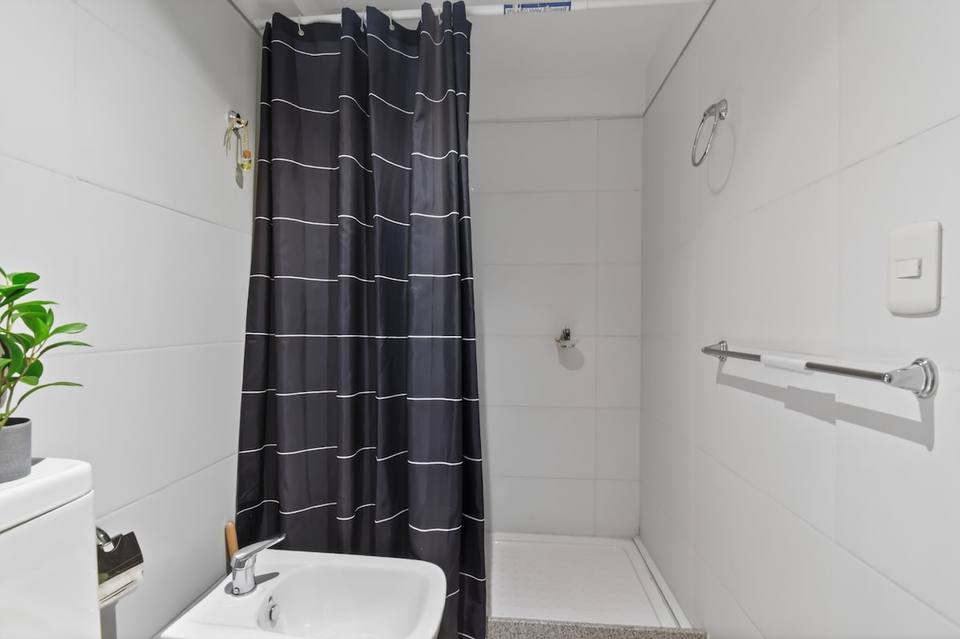 Detail of bidet and shower with striped curtain