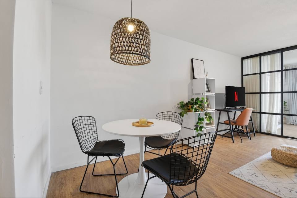 Minimalist dining area with white round table and chairs
