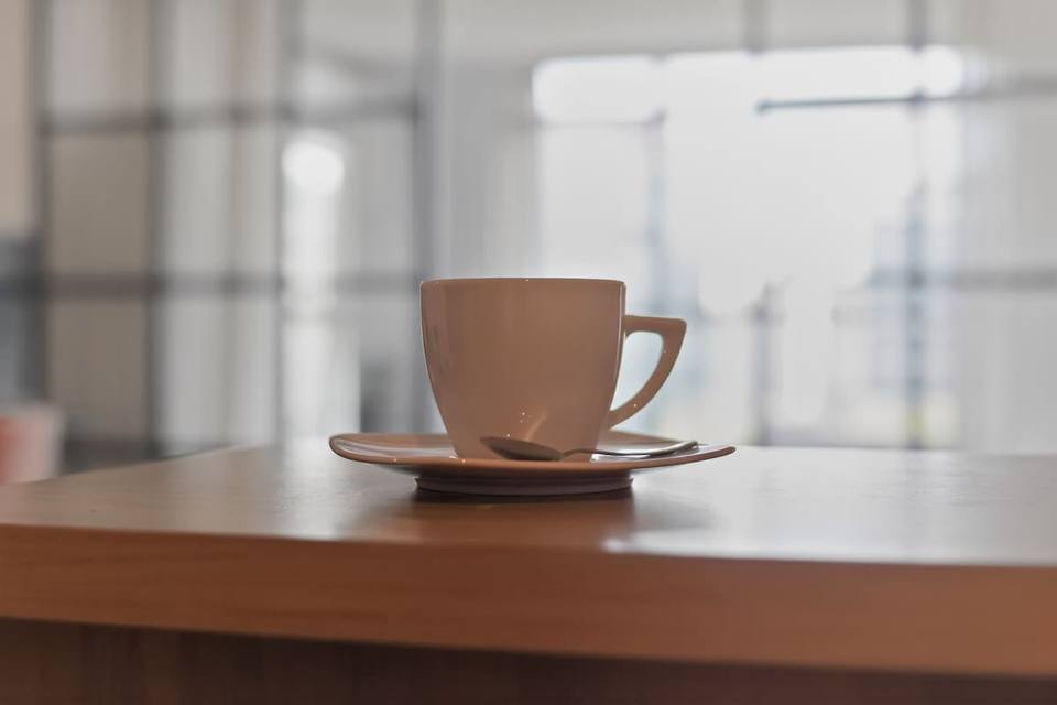 Coffee cup on wooden table, blurred background