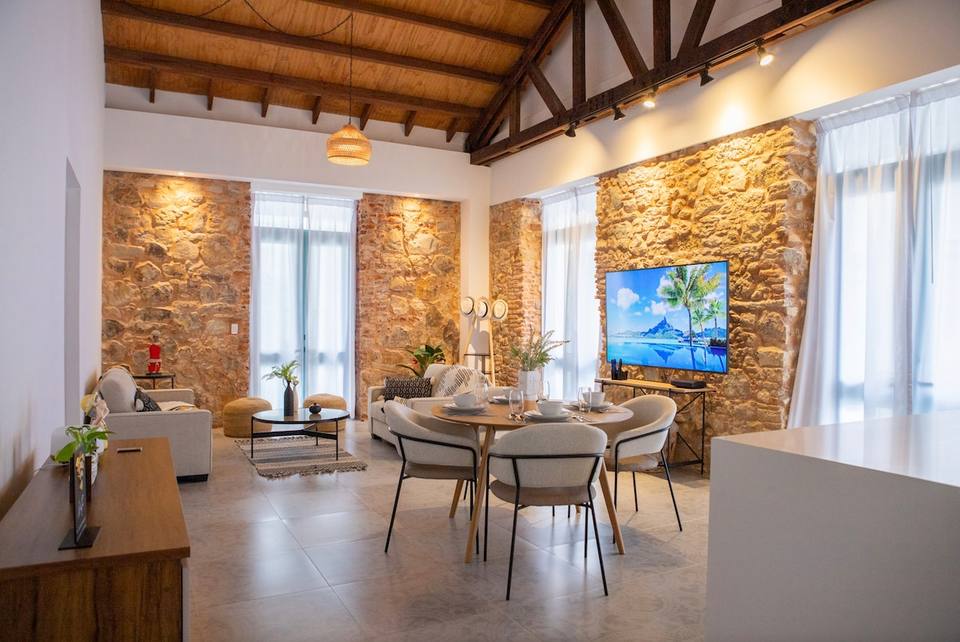 Amplio living comedor con paredes de piedra original