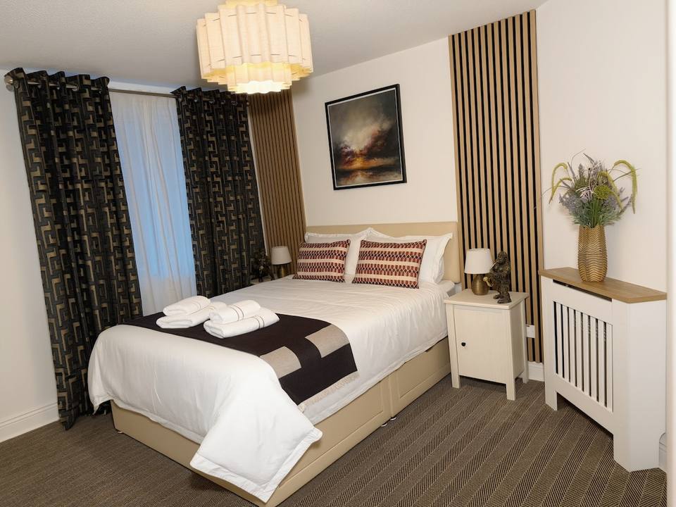 Dormitorio principal con cama King y detalles en madera