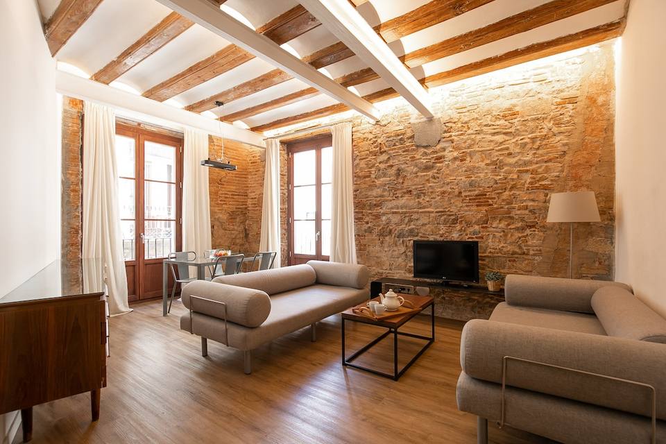 Spacious living room with stone walls and original beams