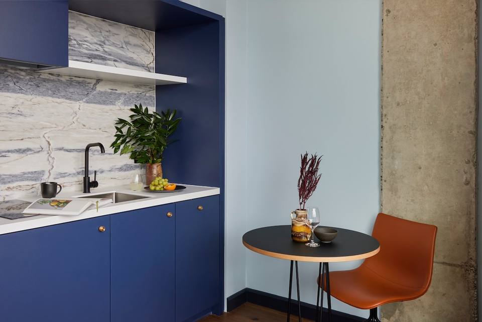Cocina integrada con detalles de mármol y comedor