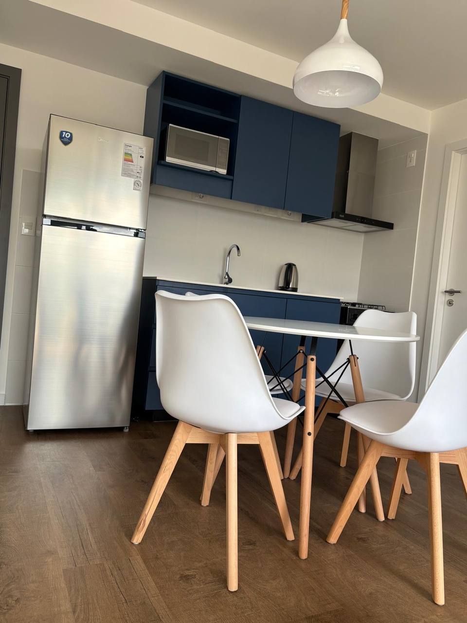 Cocina y comedor con refrigerador, horno y campana
