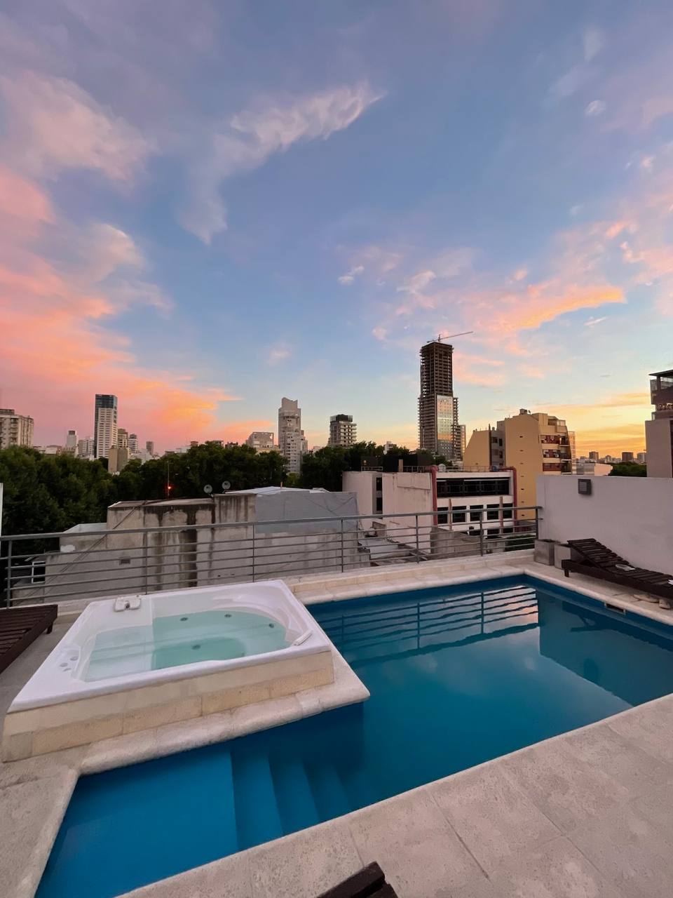 Piscina y jacuzzi en la terraza con vista abierta a la ciudad