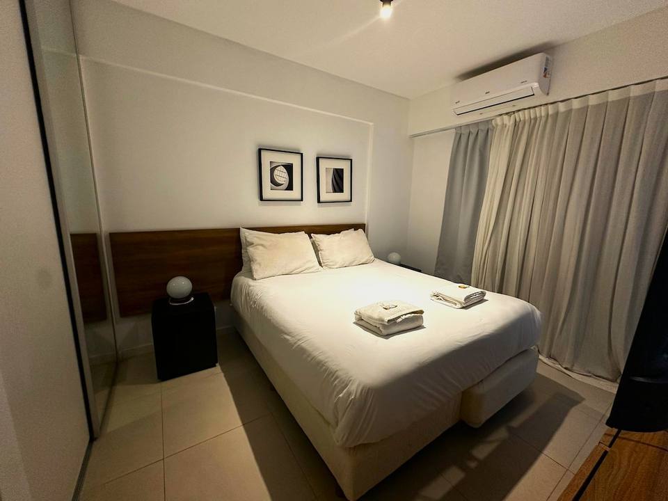 Primary bedroom with full bed and wood accents
