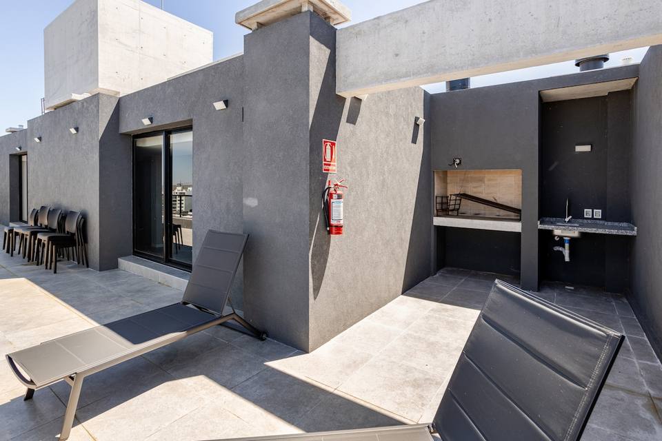 Terraza con parrilla y reposeras en azotea