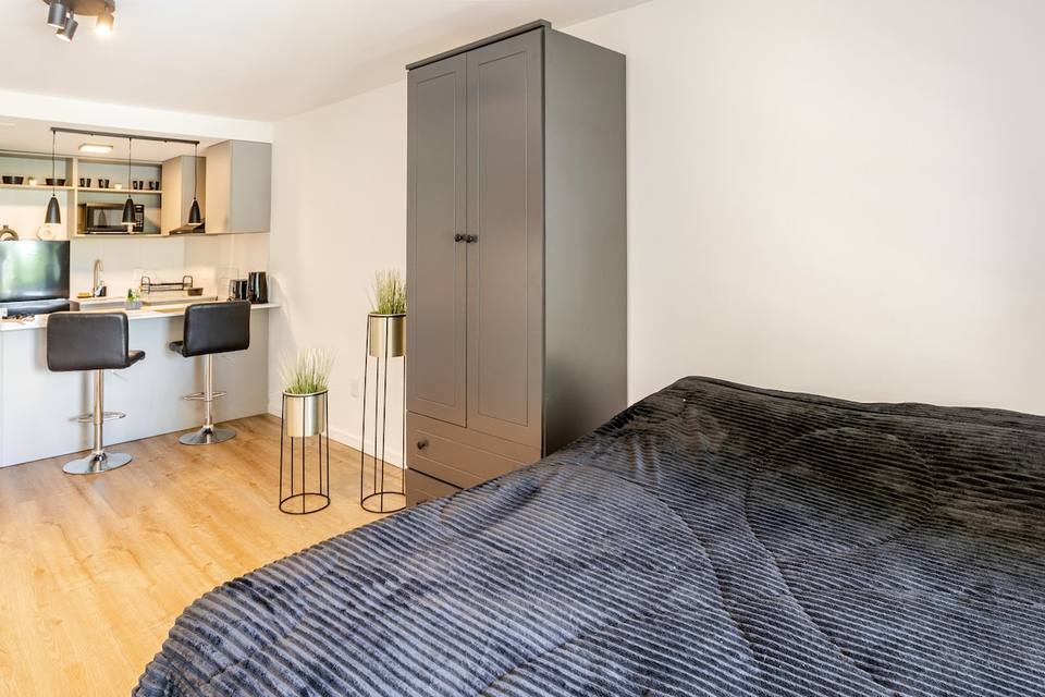 Cama, placard y la barra desayunadora de la cocina