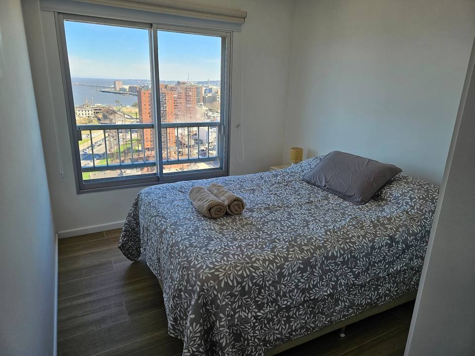 Dormitorio con cama doble y vista a la bahía