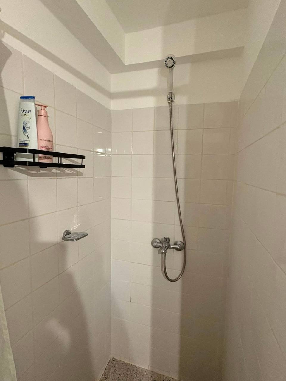 Ducha con grifería moderna y estante para artículos