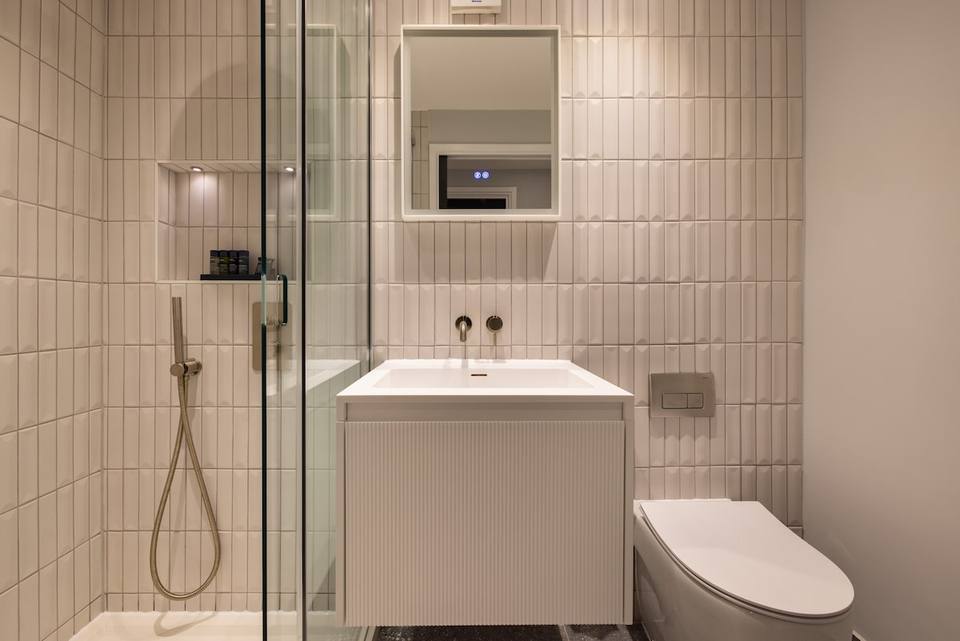 Baño moderno con ducha de lluvia y acabados de lujo
